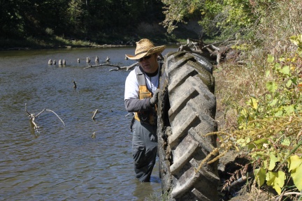 Dan Ceynar removes a tire from the river. Dan Ceynar removes a tire from the river.